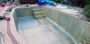 applying-matte-layer-of-fibreglass-to-concrete-pool-resurfacing